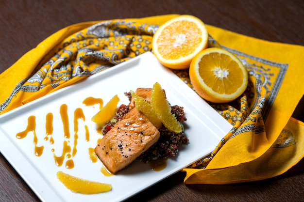 Foto gratuita salmón frito servido con arroz naranja y rojo.