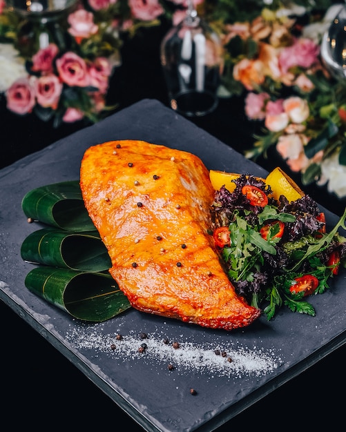 Salmón frito con verduras sobre la mesa