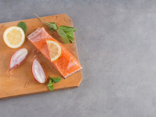 Salmón con limón sobre tabla de madera