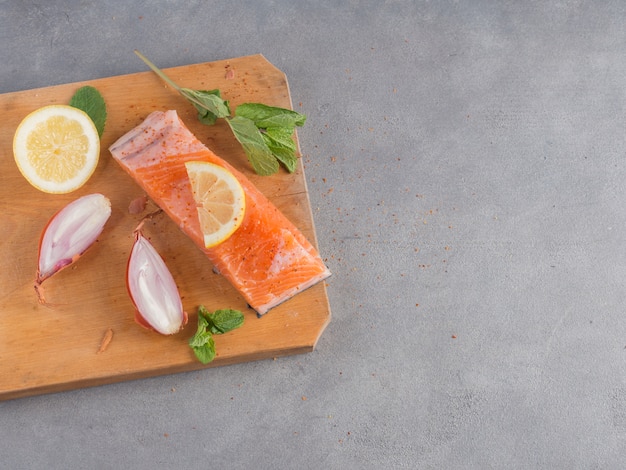 Salmón con limón sobre tabla de madera