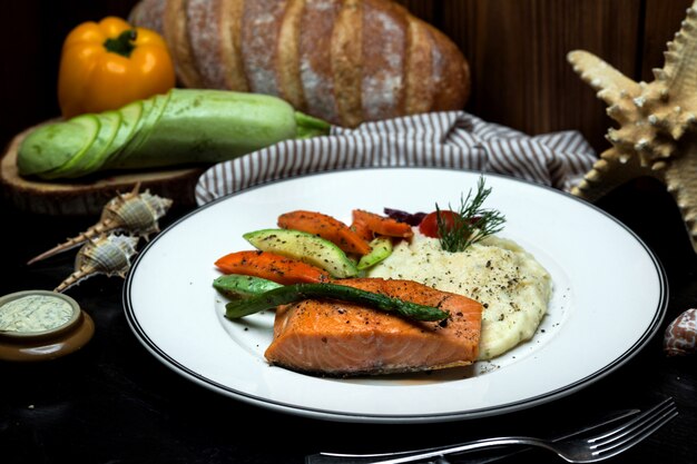 Salmón noruego y puré de papa servido con vegetales hervidos