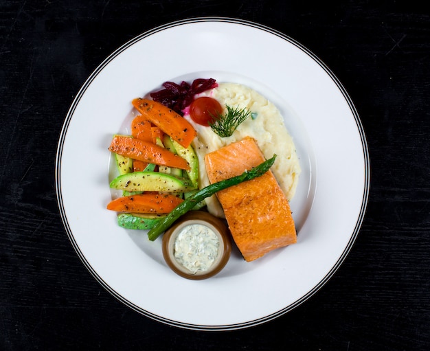 Foto gratuita salmón con verduras fritas y puré de papas