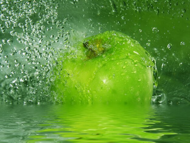 Salpicaduras de agua sobre una manzana verde