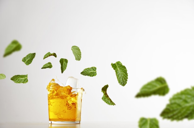 Foto gratuita salpicar limonada fresca dentro de un vaso transparente con cubitos de hielo aislado en blanco