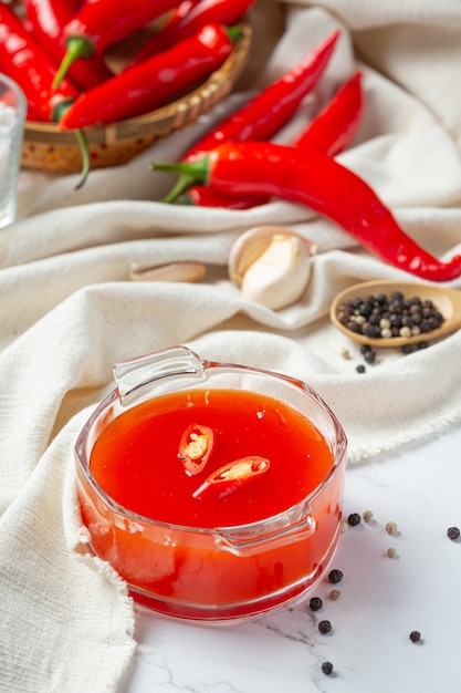 Salsa de Chile y pimientos sobre superficie blanca