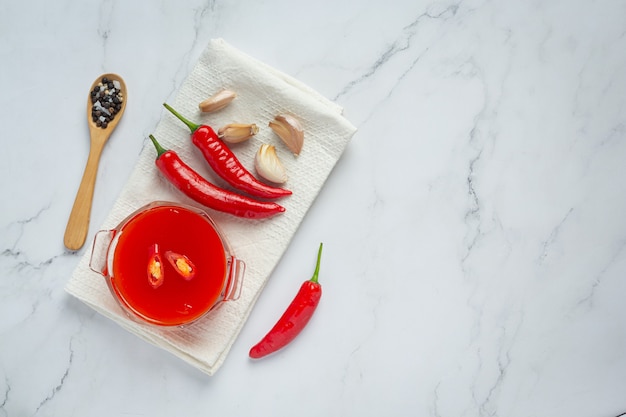 Salsa de Chile y pimientos sobre superficie blanca