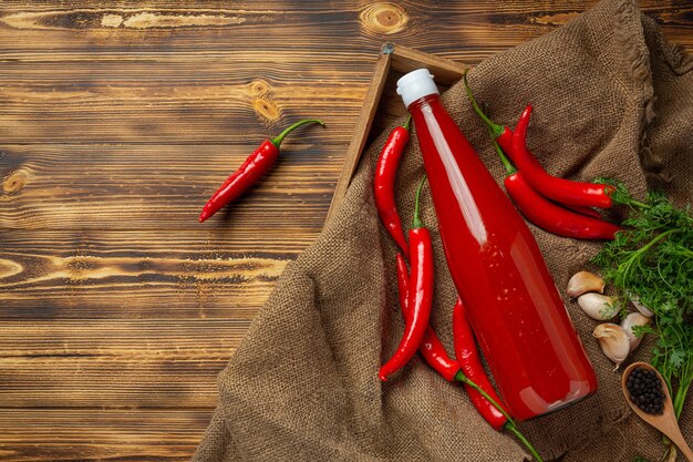 Salsa de chile y pimientos sobre la superficie de madera oscura.