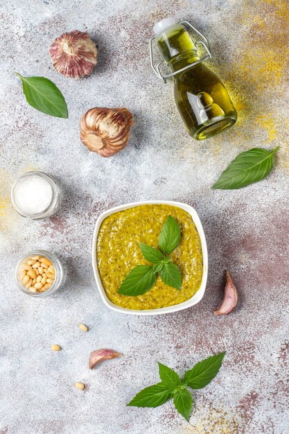 Salsa de pesto de albahaca italiana con ingredientes culinarios para cocinar.