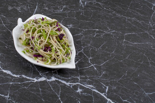 Salsa de verduras para pasta en un plato sobre negro.