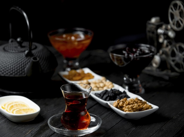 Salto de té con un vaso de té y bocadillos, nueces.