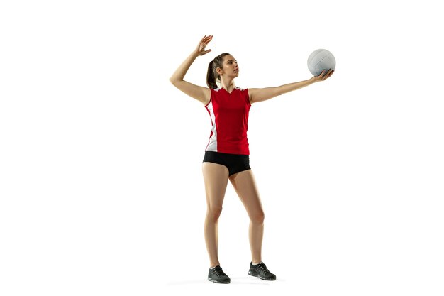 En salto y vuelo. Jugador de voleibol femenino joven aislado sobre fondo blanco de estudio. Mujer en ropa deportiva y zapatillas de deporte, jugando. Concepto de deporte, estilo de vida saludable, movimiento y movimiento.