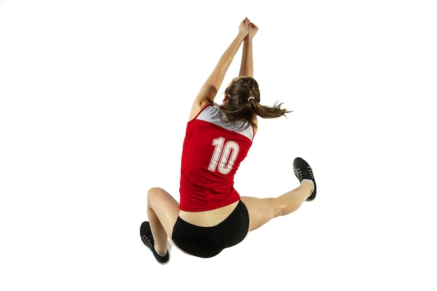 En salto y vuelo. Jugador de voleibol femenino joven aislado sobre fondo blanco de estudio. Mujer en ropa deportiva y zapatillas de deporte, jugando. Concepto de deporte, estilo de vida saludable, movimiento y movimiento.
