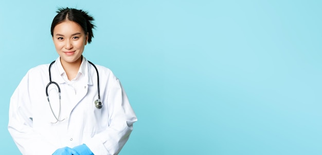 Foto gratuita salud y concepto médico sonriente doctora asiática en uniforme de hospital y estetoscopio looki