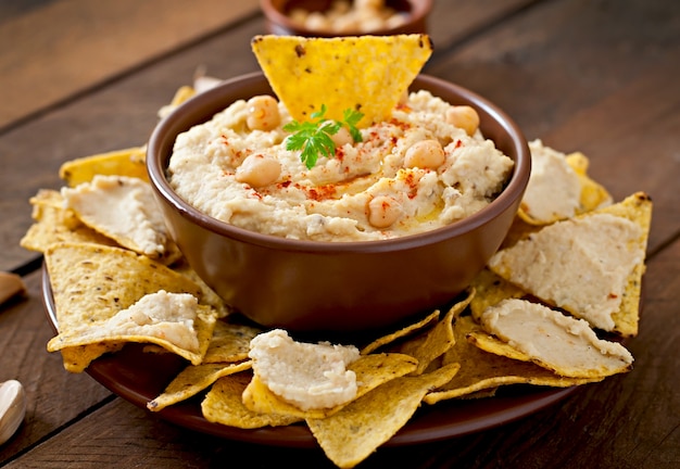 Saludable hummus casero con aceite de oliva y chips de pita