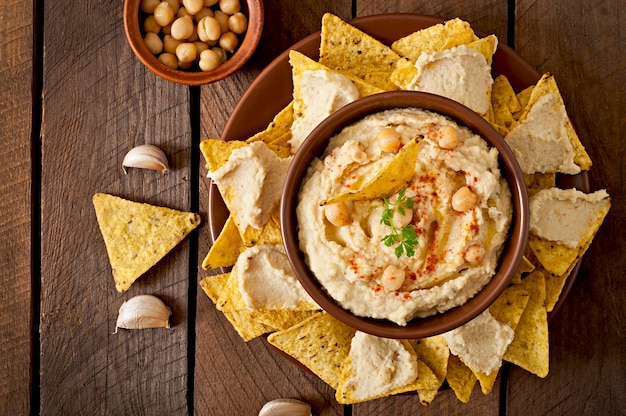 Saludable hummus casero con aceite de oliva y chips de pita