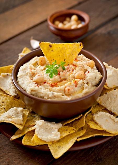 Foto gratuita saludable hummus casero con aceite de oliva y chips de pita