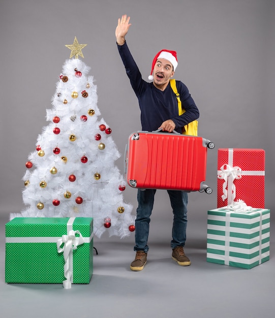 saludando a joven con gorro de Papá Noel en gris