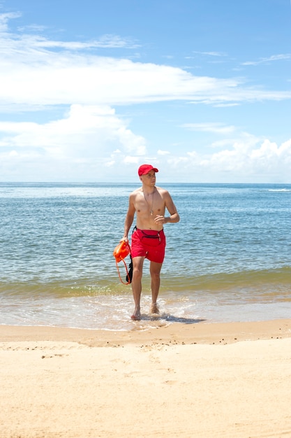 Foto gratuita salvavidas corriendo en la vista frontal de la playa