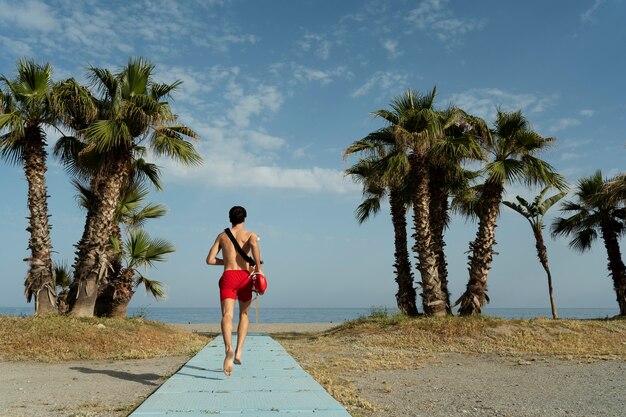 Salvavidas de tiro completo corriendo en la playa