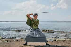 Foto gratuita samurai con espada en la playa