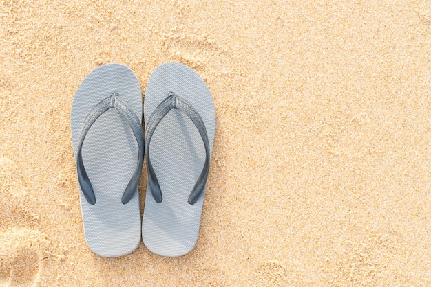 sandalias en la costa de arena del mar