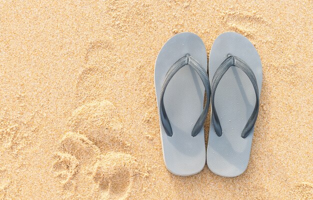 sandalias en la costa de arena del mar