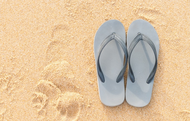 sandalias en la costa de arena del mar