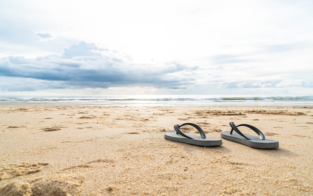 Foto gratuita sandalias en la costa de arena del mar