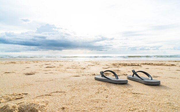sandalias en la costa de arena del mar