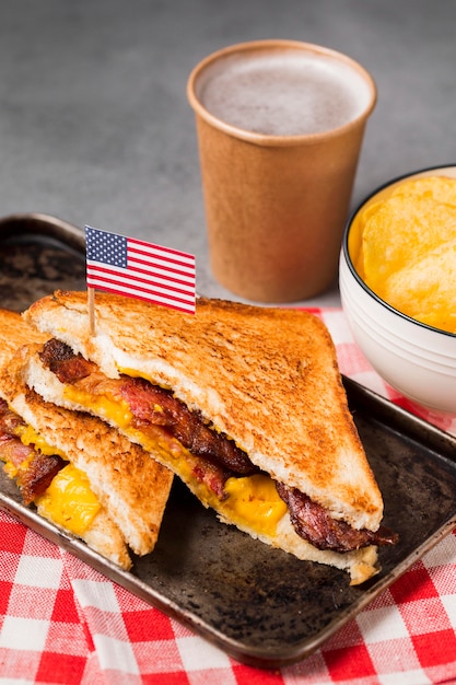 Sándwich de alto ángulo con tocino y queso con patatas fritas