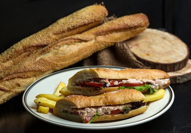 Sandwich de atún con mayonesa, tomate, lechuga, servido con papas fritas