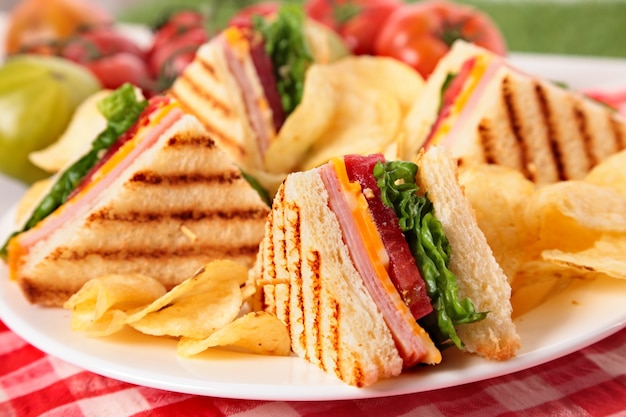Sandwich club con jamón y queso en plato