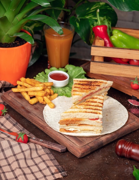 Sándwich Club servido con papas fritas y refrescos, mayonesa, salsa de tomate