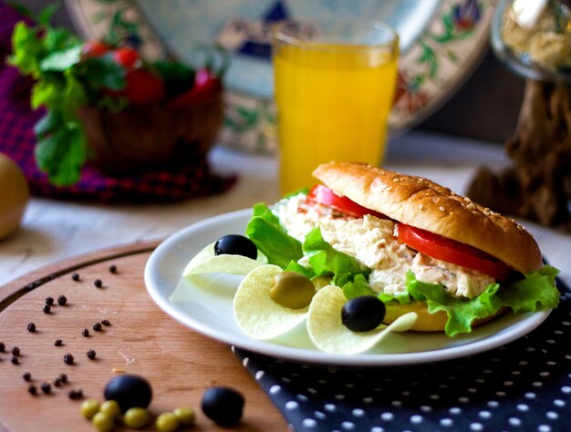 Sandwich con ensalada cremosa y chips con aceitunas