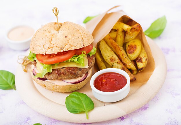 Sándwich grande: hamburguesa con jugosa hamburguesa de ternera, queso, tomate, cebolla roja y papas fritas.