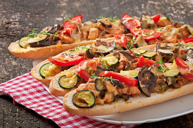 Sándwich grande con verduras asadas (calabacín, berenjenas, tomates) con queso y tomillo.