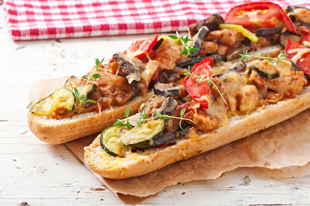 Sándwich grande con verduras asadas (calabacín, berenjenas, tomates) con queso y tomillo.