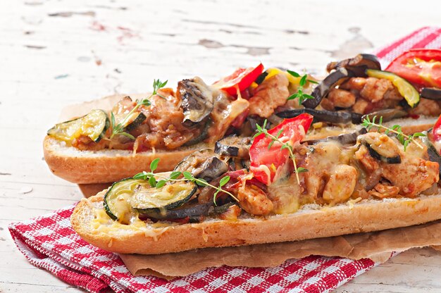 Sándwich grande con verduras asadas (calabacín, berenjenas, tomates) con queso y tomillo.