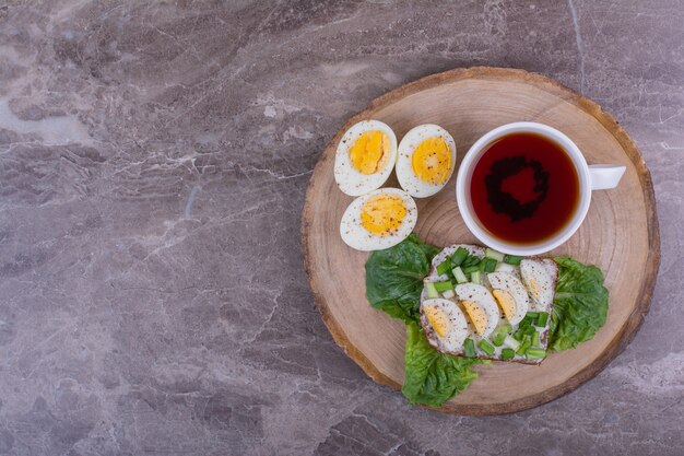 Sándwich de huevo con hierbas y una taza de té