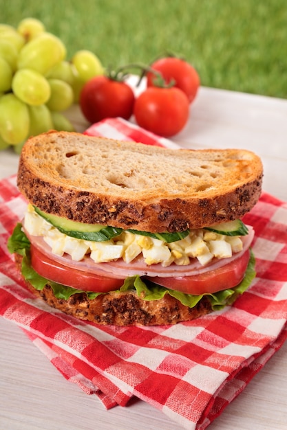 Sándwich de jamón y huevo en mesa de picnic