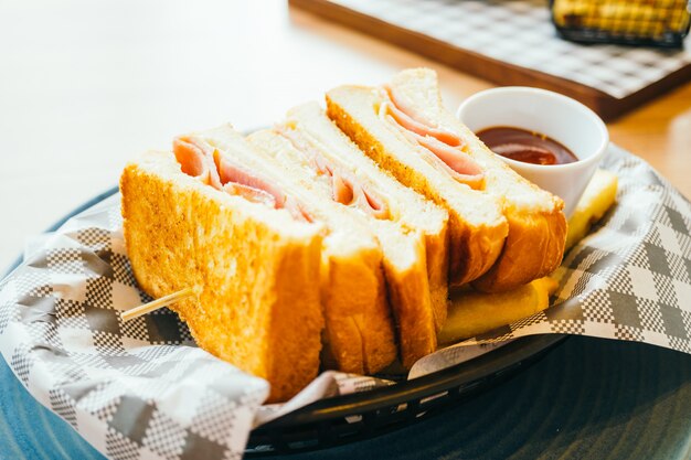 Sándwich de jamón con queso y papas fritas y salsa de tomate.