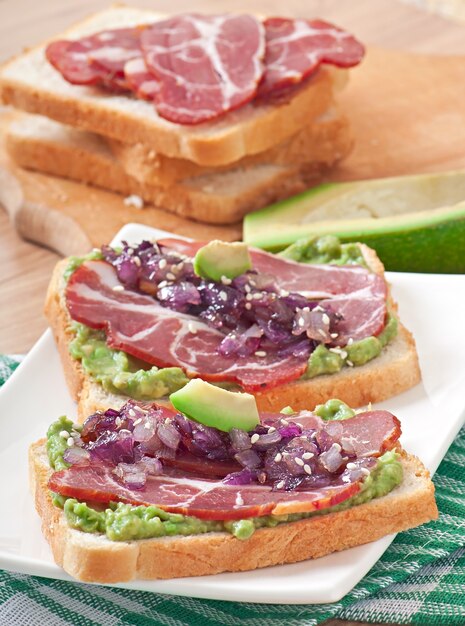 Sandwich con jamón, salsa de aguacate y cebolla caramelizada