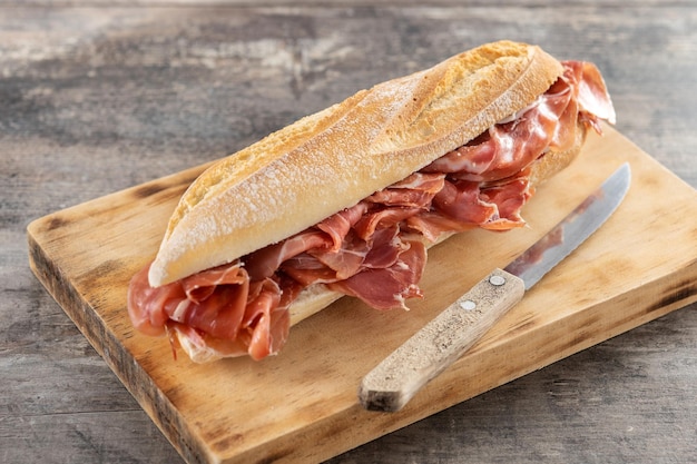 Sandwich de jamón serrano español en mesa de madera