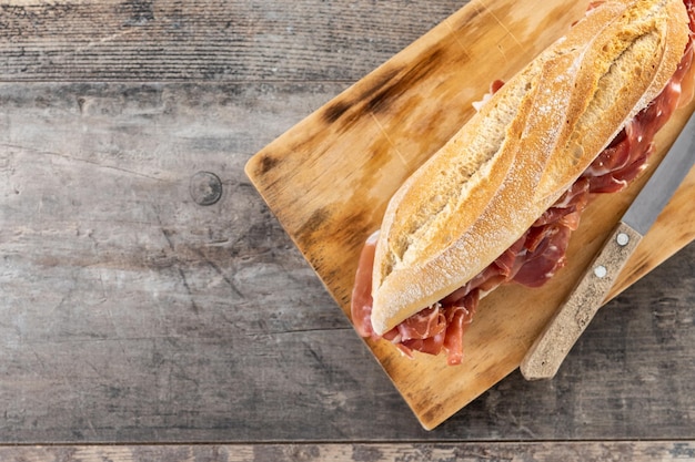 Sandwich de jamón serrano español en mesa de madera