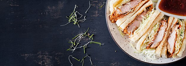 sándwich japonés con chuleta de cerdo empanada, col y salsa tonkatsu.