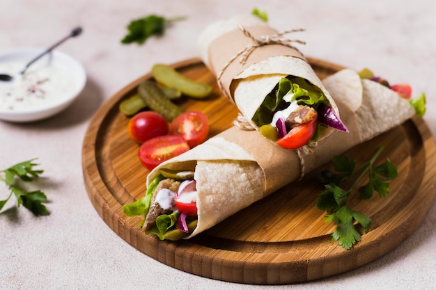 Sándwich de kebab árabe sobre tabla de madera vista alta