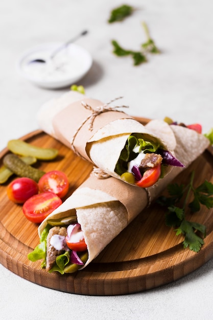 Foto gratuita sándwich de kebab árabe sobre tabla de madera