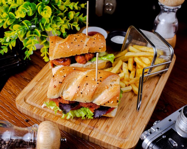 Sandwich de nuggets de pollo servido con papas fritas