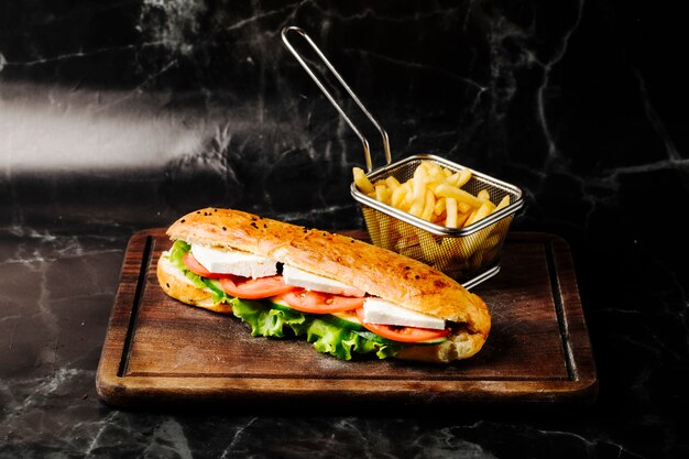 Sándwich en pan tandir con queso blanco, tomate y lechuga en el interior.