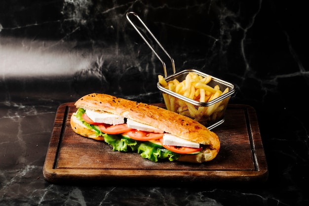 Sándwich en pan tandir con queso blanco, tomate y lechuga en el interior.